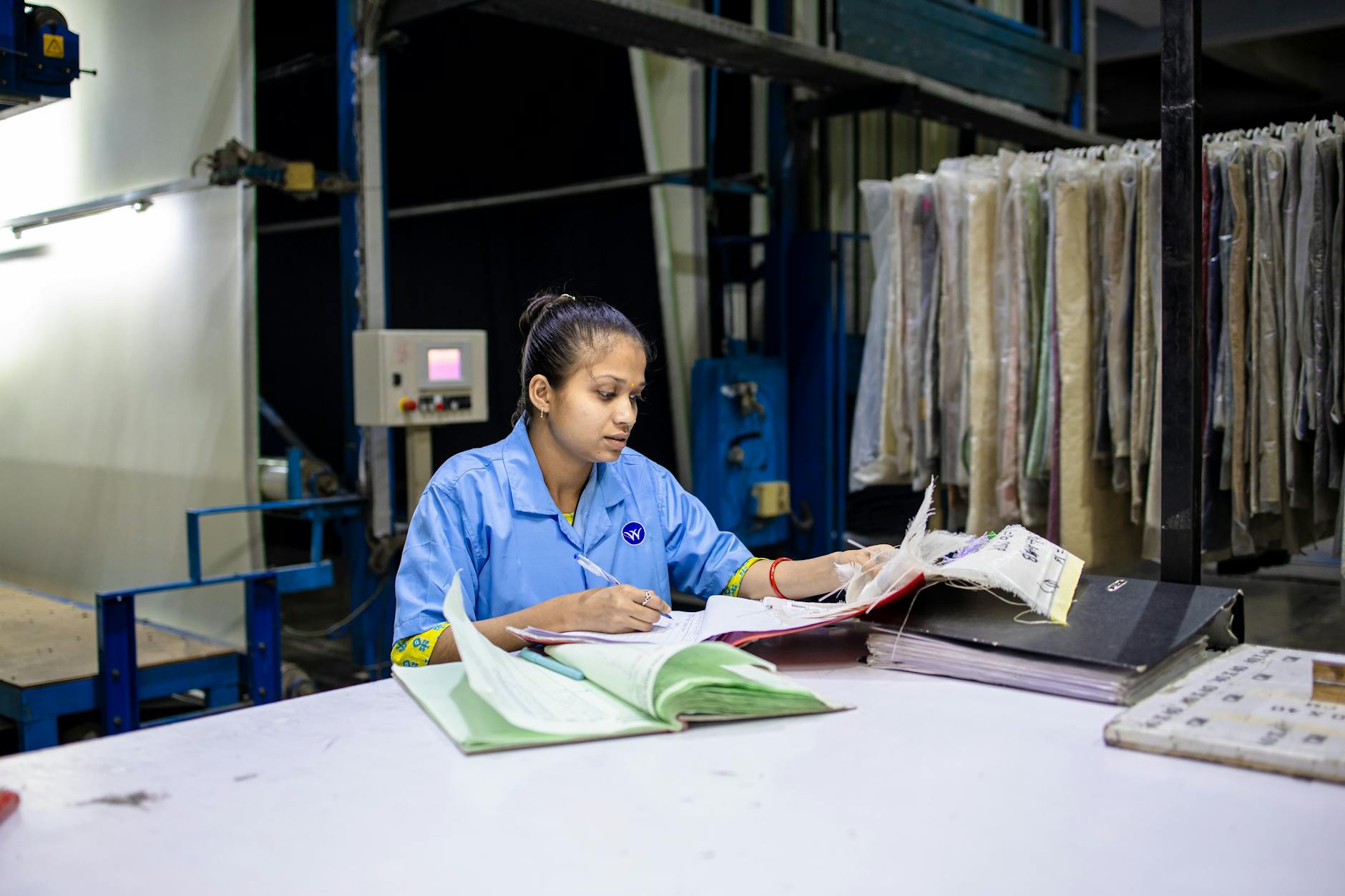 Indian factory worker reviewing paper quality specifications and documents at a workstation