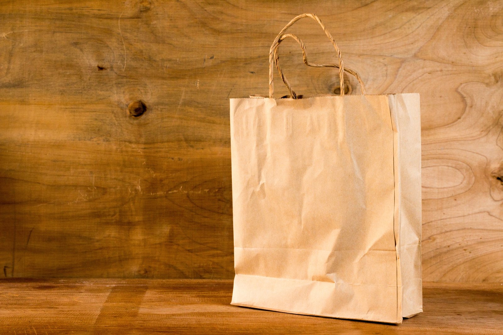 Brown kraft paper carry bag with twisted handles, the format organised retailers specify for store bags