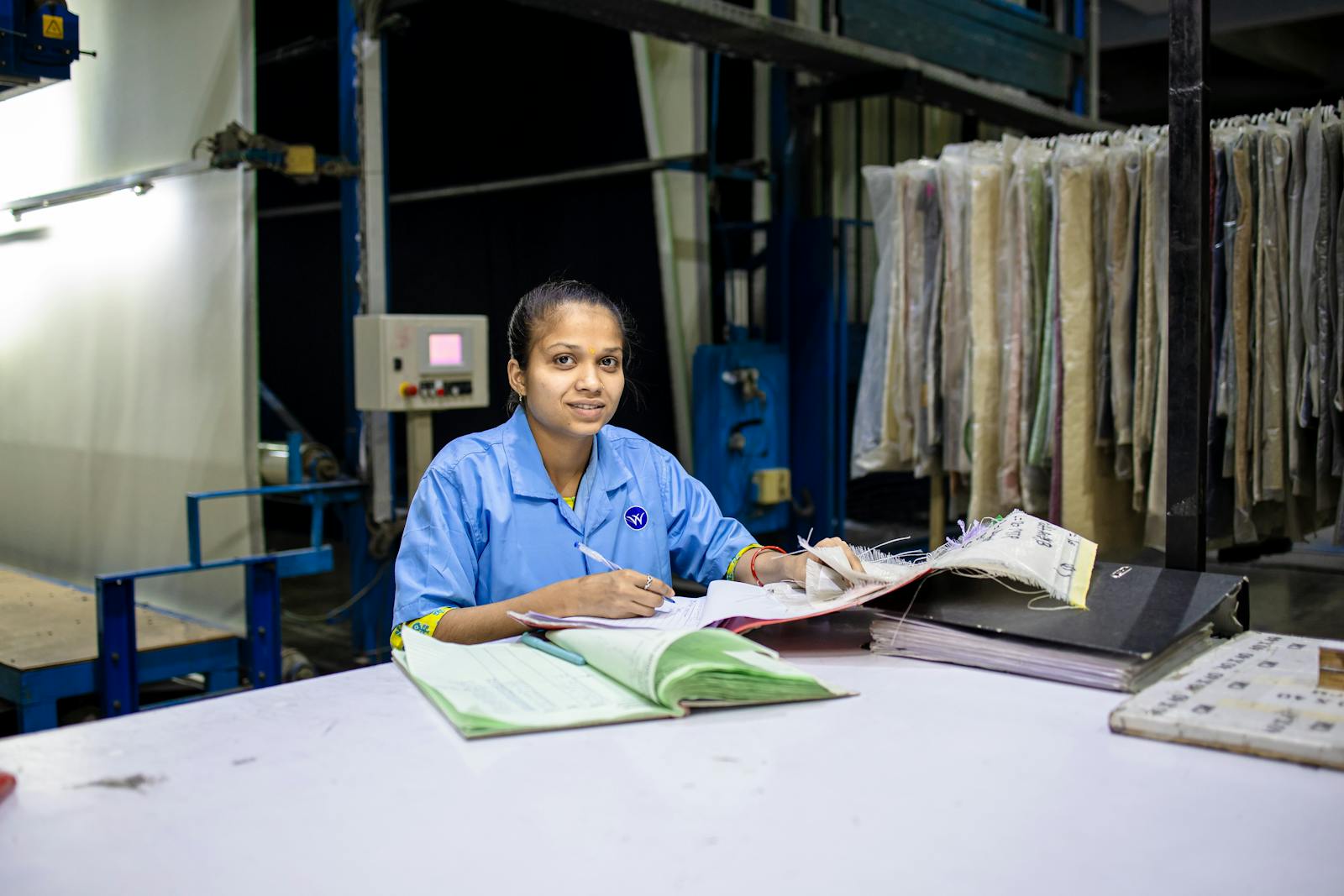 Indian factory worker reviewing documents at a desk, mirroring the compliance pack a QSR RFQ response must include
