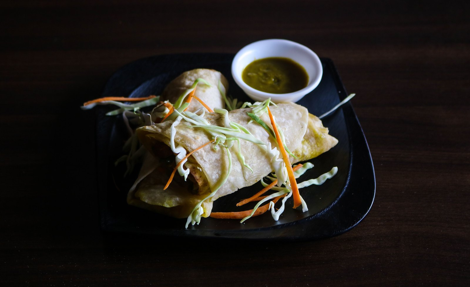 Indian wraps served with green chutney on a plate, ready-to-eat food that requires food-safe, low-migration paper packaging.