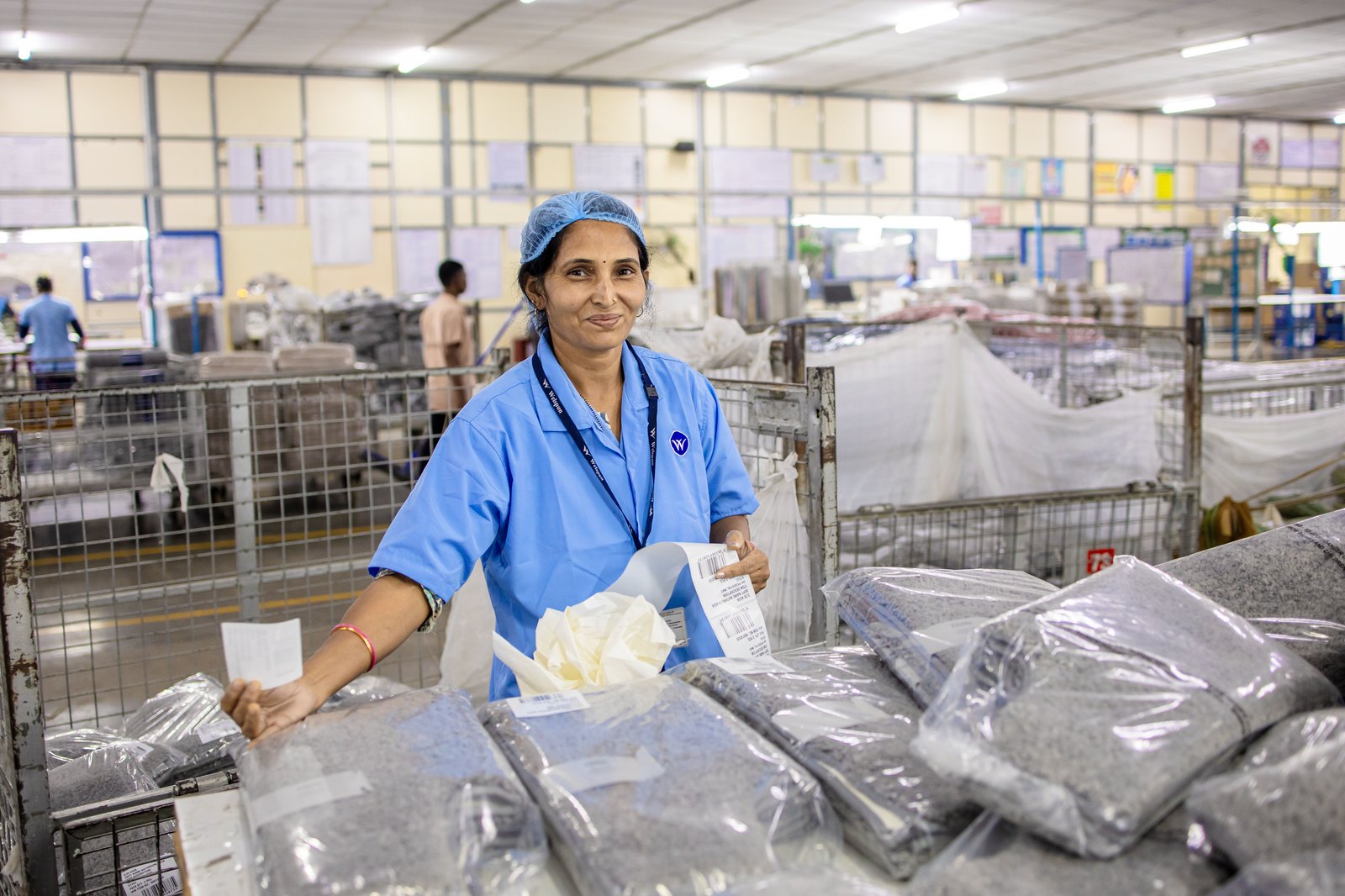 Indian factory worker handling finished packages in a manufacturing dispatch area