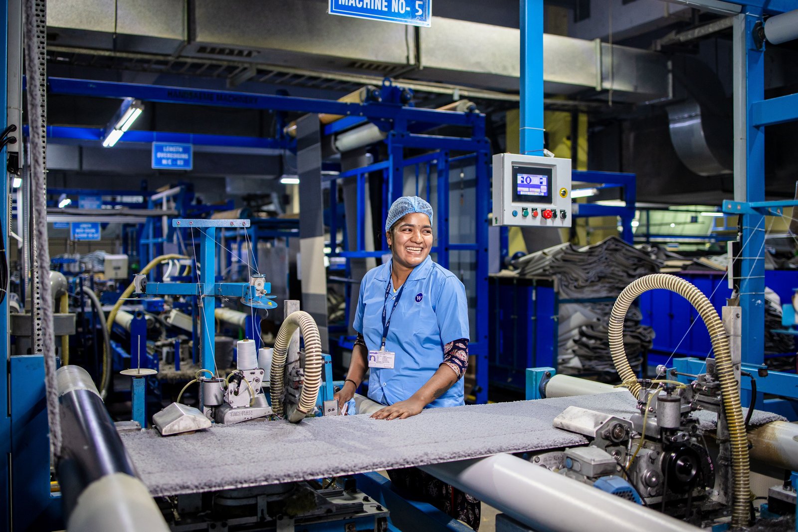 Operator running industrial machinery in an Indian factory, representing web tension control on a paper bag printing line