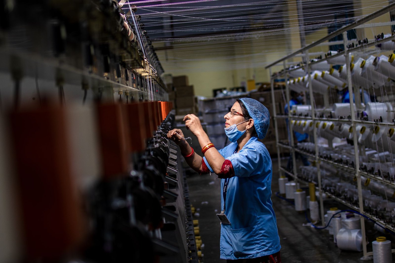 Quality-control check on running machinery in an Indian factory, representing web tension and runnability testing on a converting line