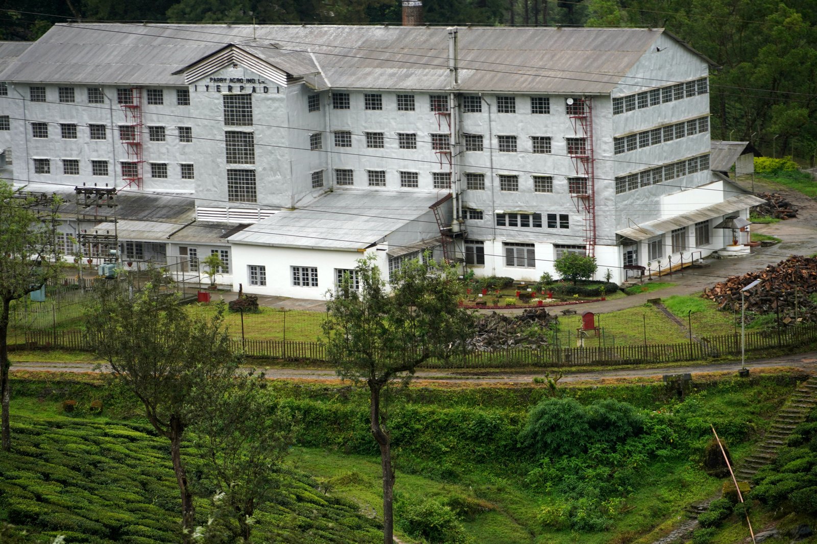 Tea factory surrounded by lush green hills in Valparai, Tamil Nadu, India