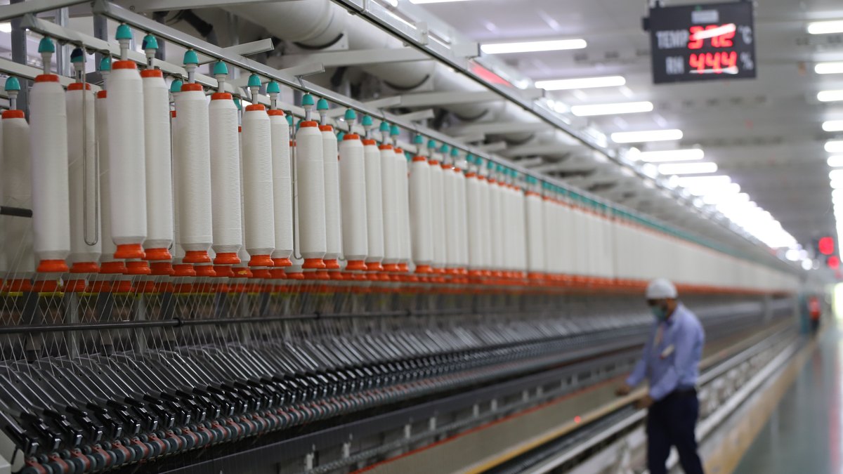 Operator managing machinery in a modern industrial plant in India, the coating line environment where a porous base shows up as silicone consumption