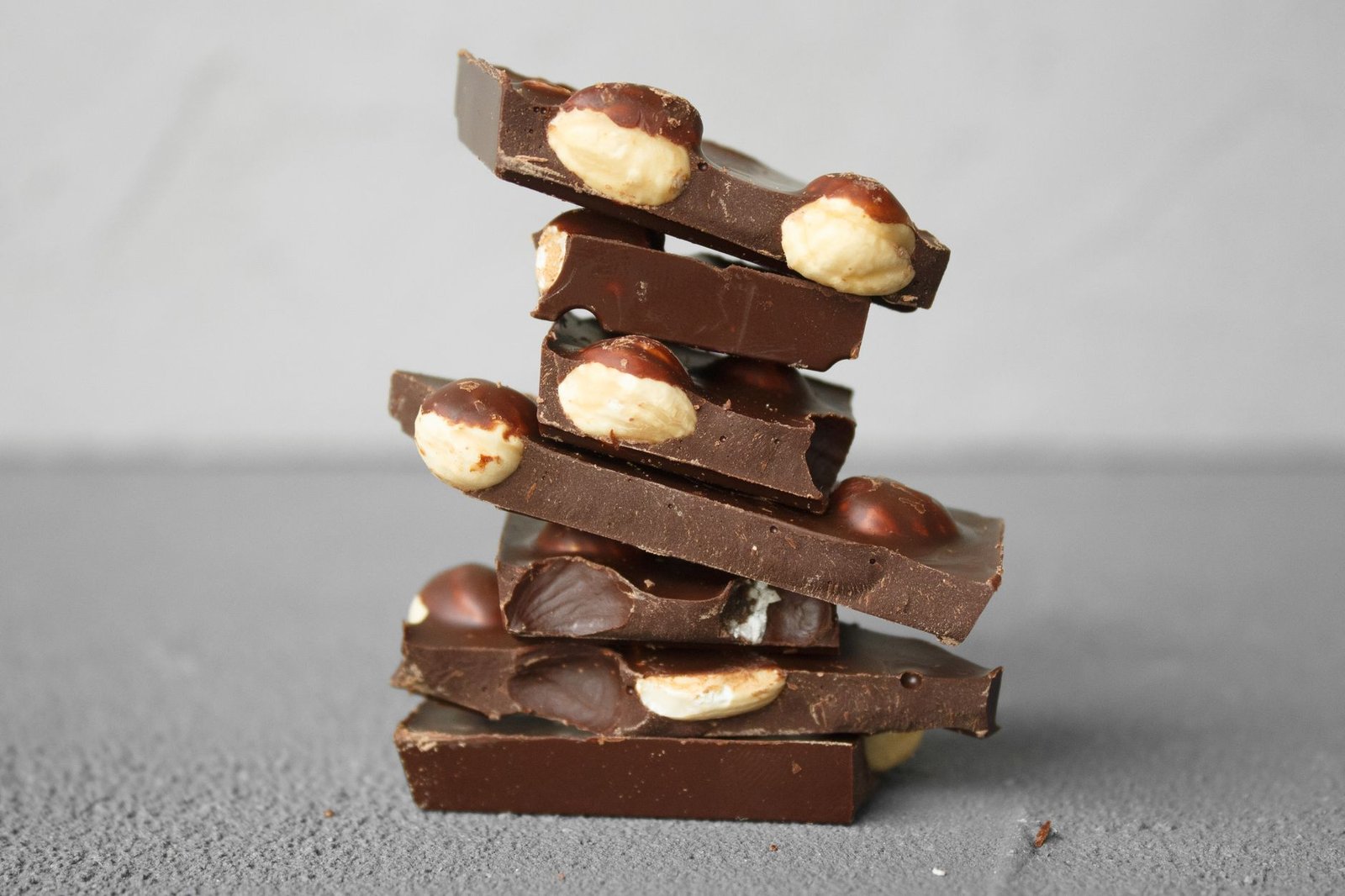Stack of dark chocolate bars with nut inclusions that require low-OTR barrier packaging