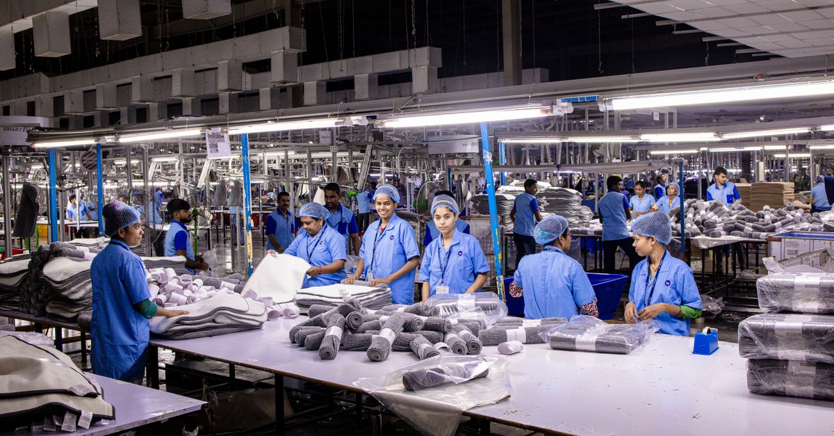 Indian factory workers packaging finished products on an assembly line