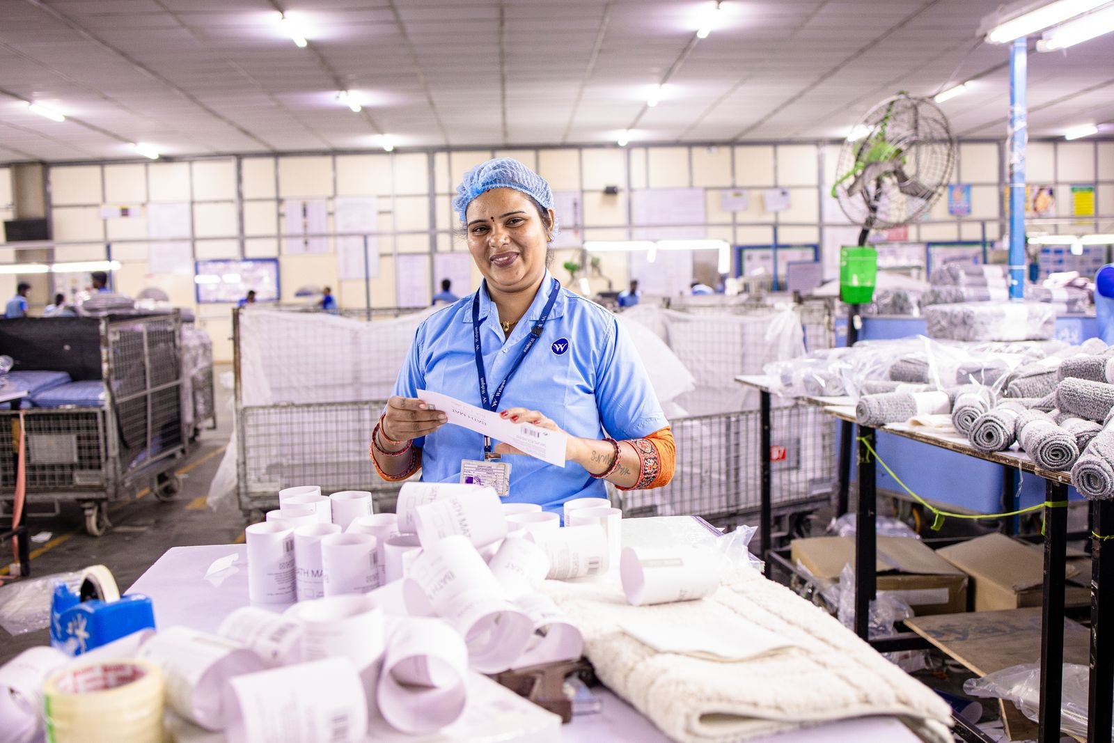 Worker inspecting product labels on a production line inside an Indian factory