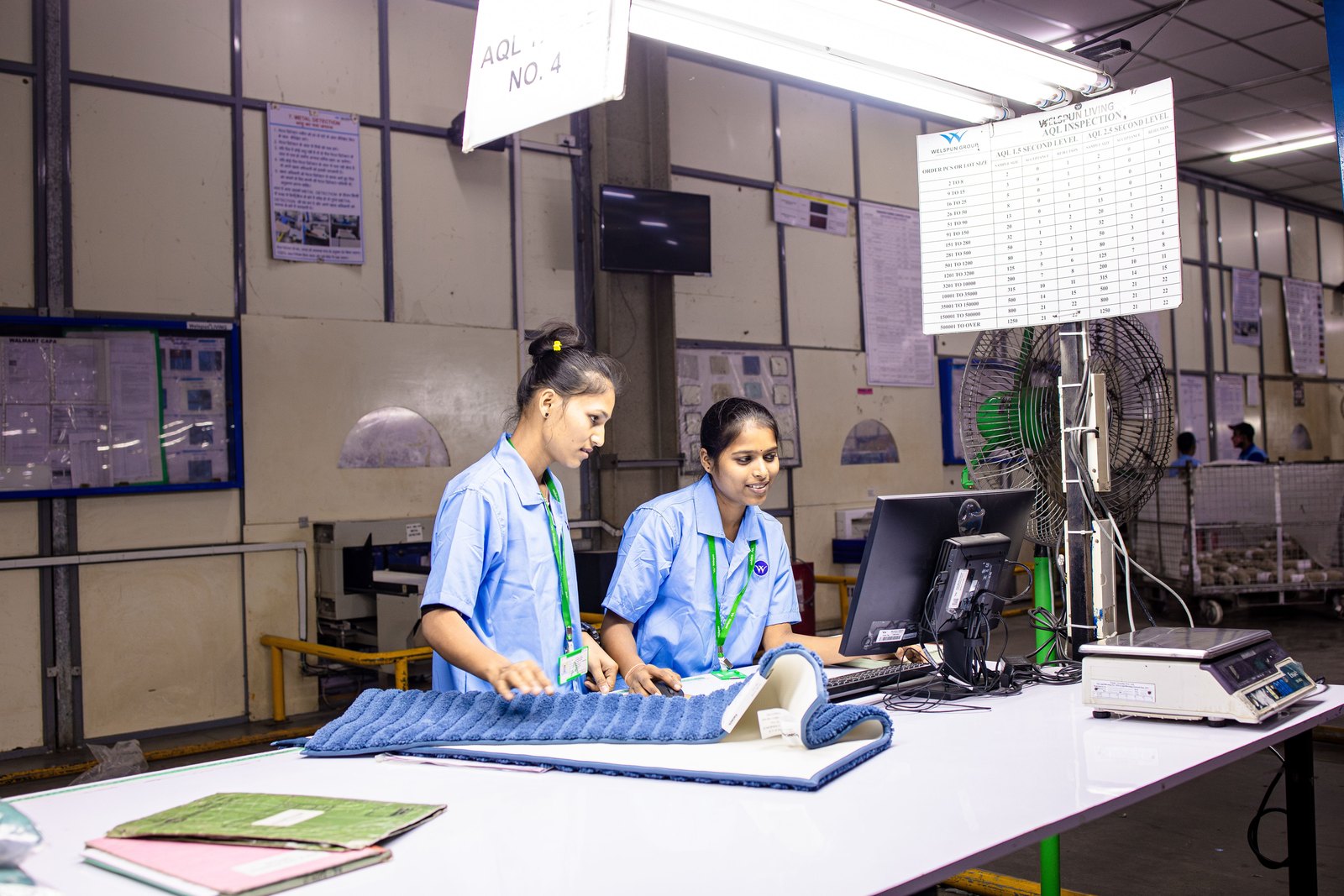 Indian factory workers inspecting products at a quality station, verifying IS 14490 performance