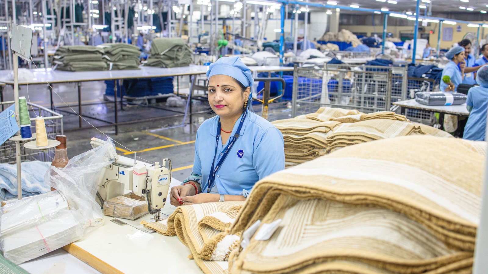 Indian factory worker at an industrial production line, the setting in which sachet paper reels are converted, filled and sealed