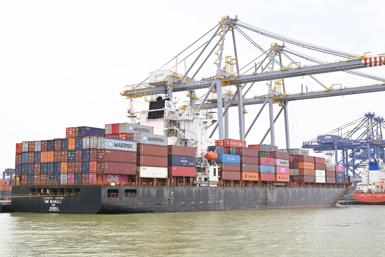 Cargo vessel loading containers at an Indian port, illustrating imported base paper logistics
