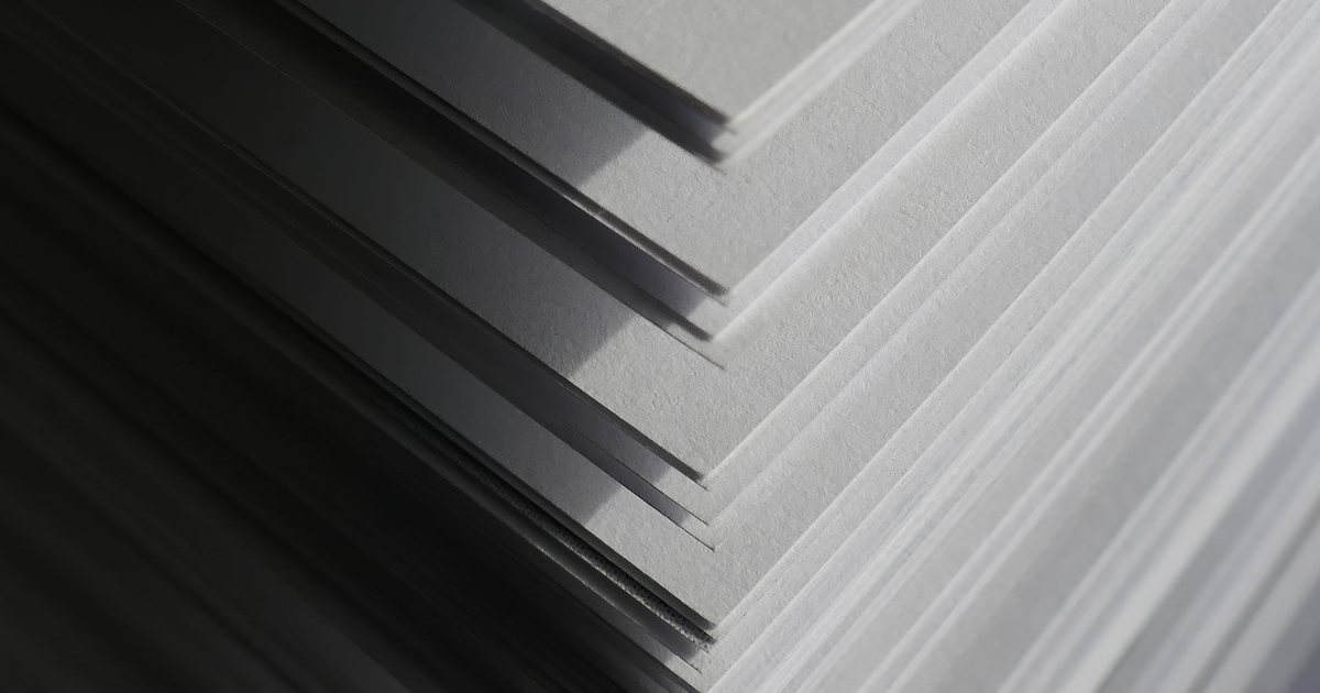 Close-up of stacked white uncoated paper sheets showing their edges and surface texture