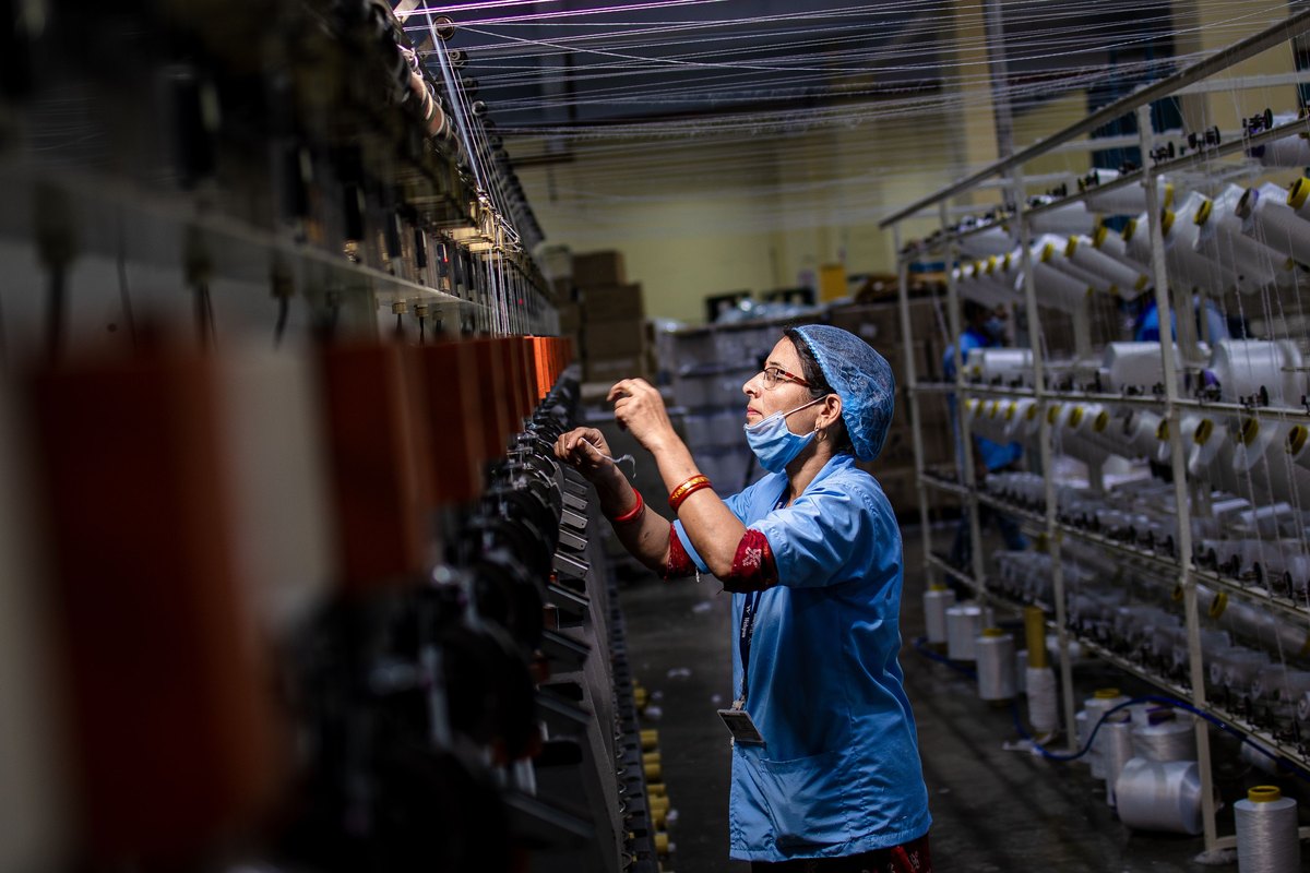Worker carrying out quality control checks on production machinery at an Indian factory
