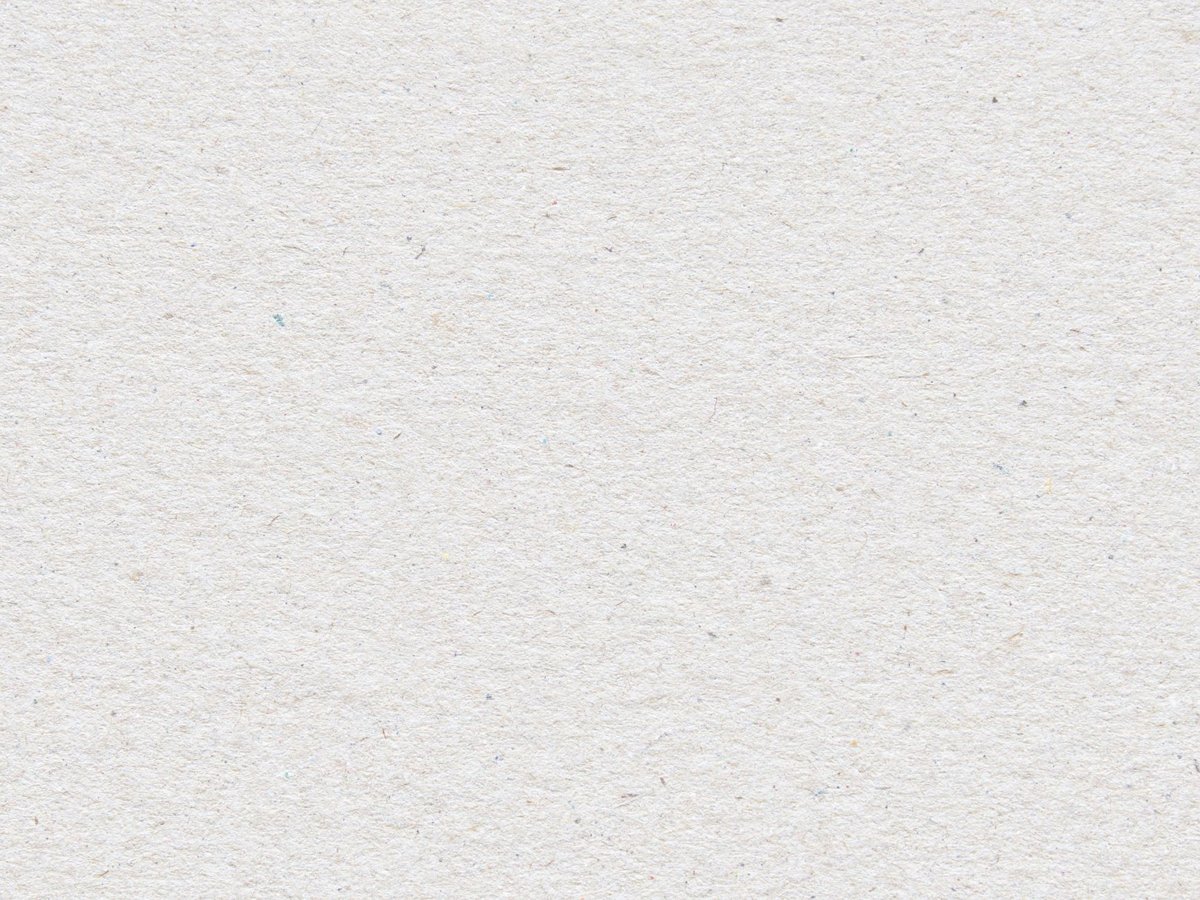 Close view of an uncoated white paper surface, showing loose fibres and a slightly open, matt texture