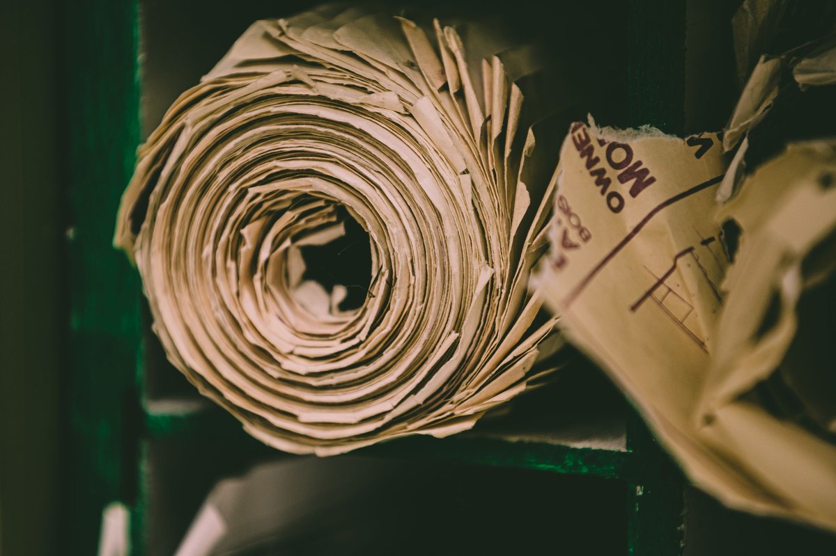 Reel of unbleached kraft paper on a storage rack, the natural brown fibre colour that residual lignin gives the sheet