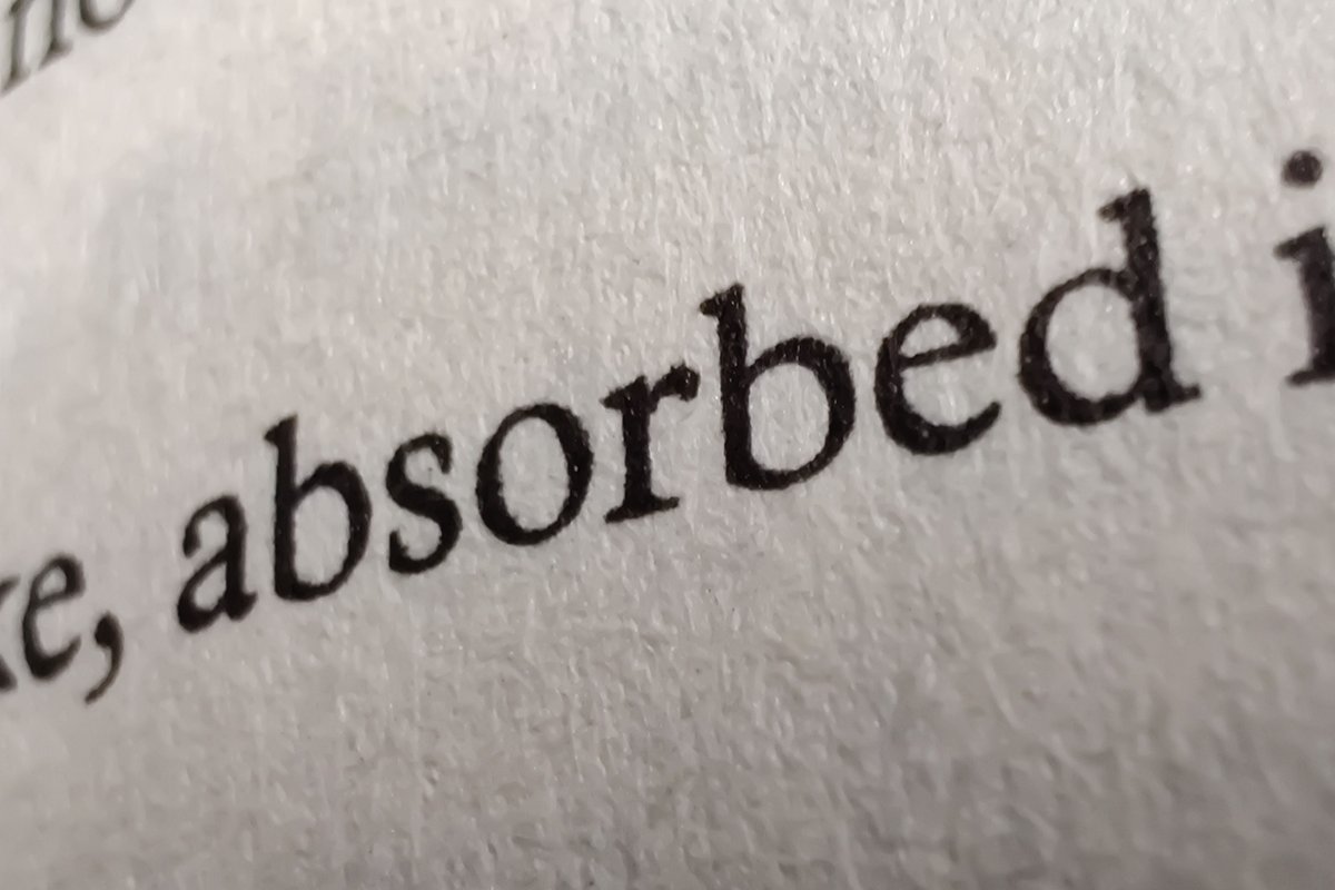 Macro of black printed text on an uncoated paper sheet with visible fibre texture