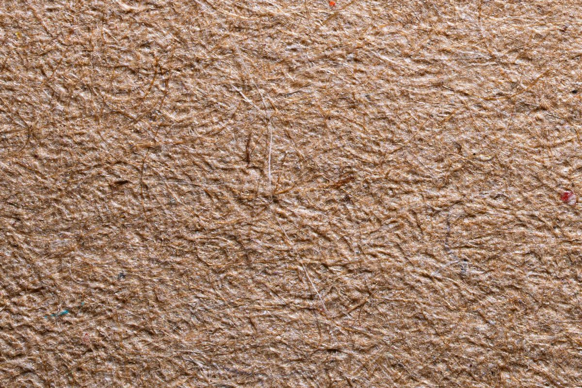 Close view of an open, fibrous brown paper surface with individual fibres visible